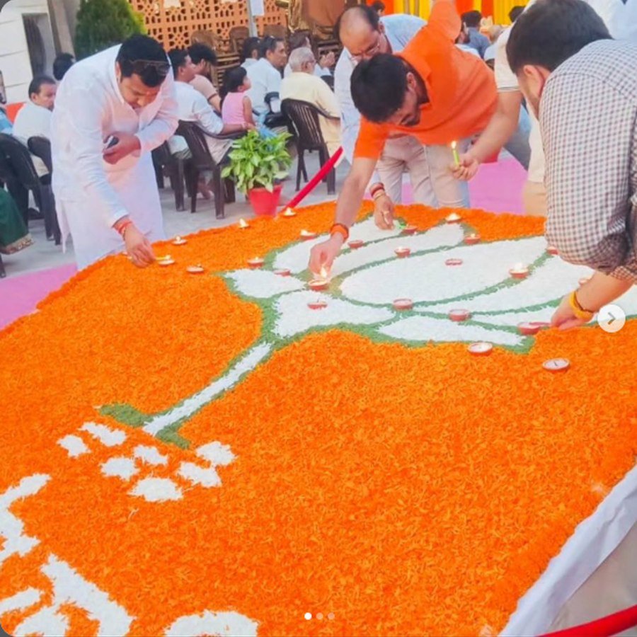 Participants lighting ceremonial lamps at a floral display